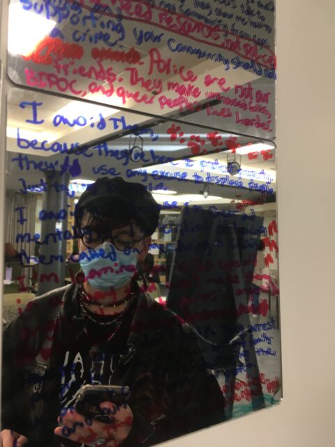 un jeune se regarde dans un miroir sur lequel est écrit : la police n'est pas notre amie
