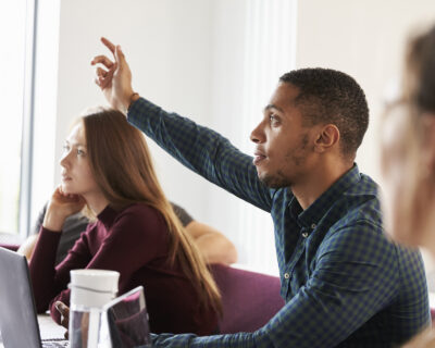 Students Asking Question Whilst Attending Lecture On Campus