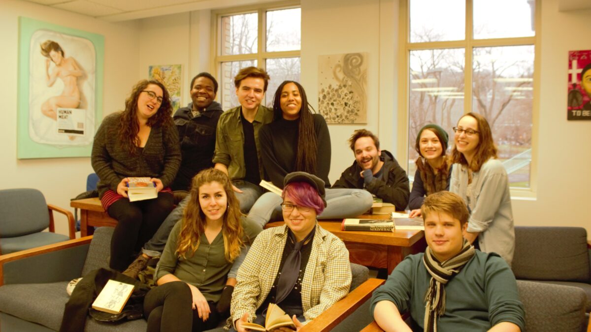 un groupe d'étudiants souriants assis sur un canapé devant une fenêtre