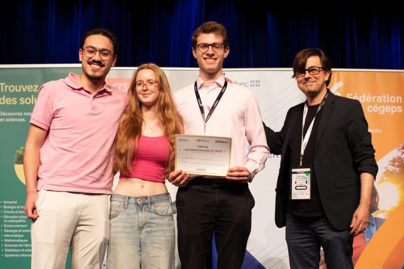 Trois étudiants se tenant par le bras, l'un d'eux tenant un certificat de récompense