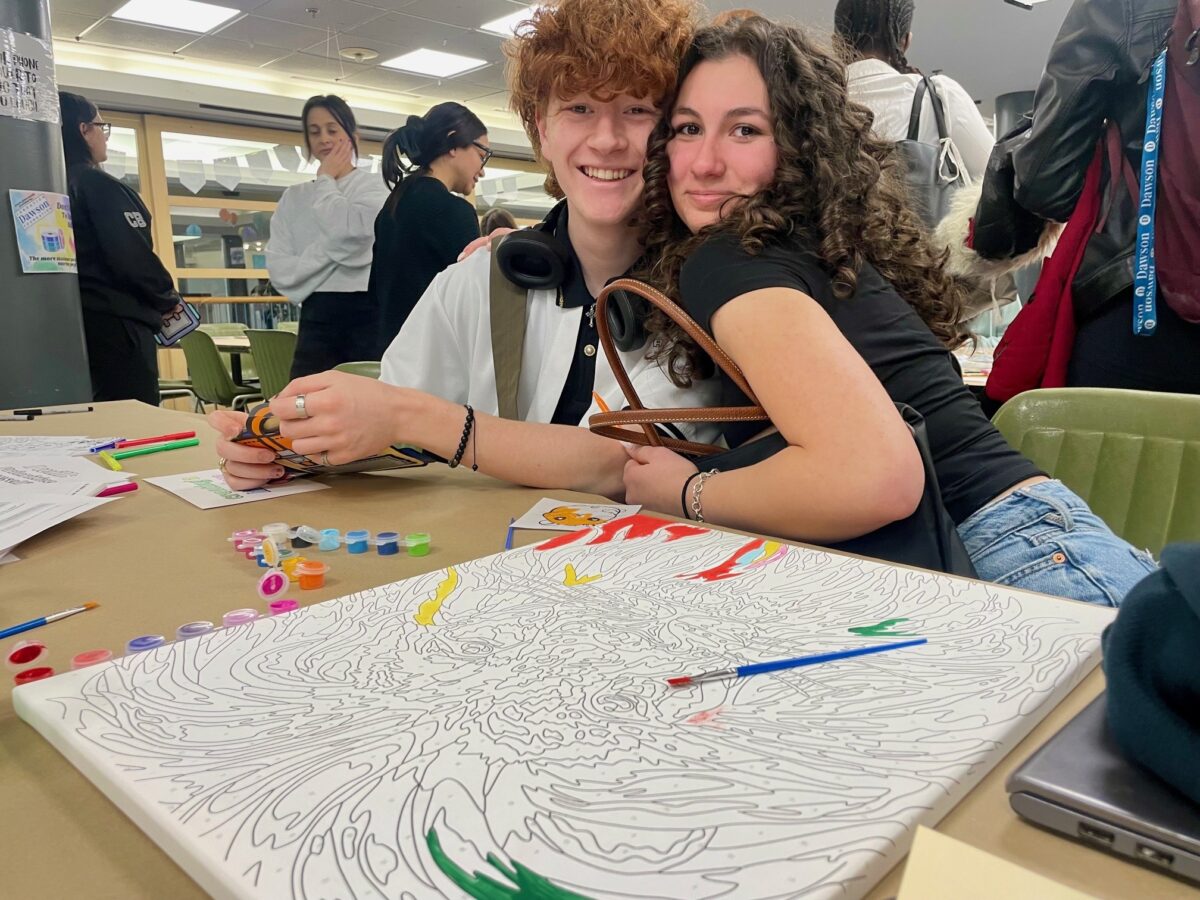 two students enjoying a colouring/painting station in an on-campus self-care fare