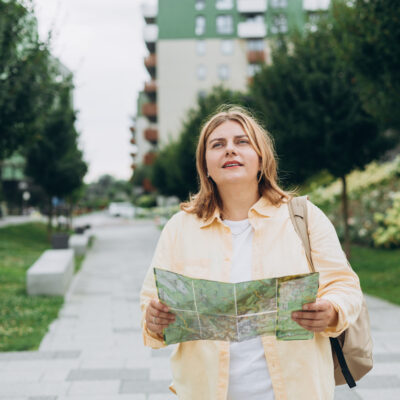 élève levant les yeux d'une carte pour regarder les bâtiments devant elle