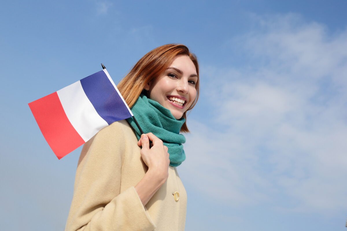 une jeune femme heureuse tenant un drapeau français
