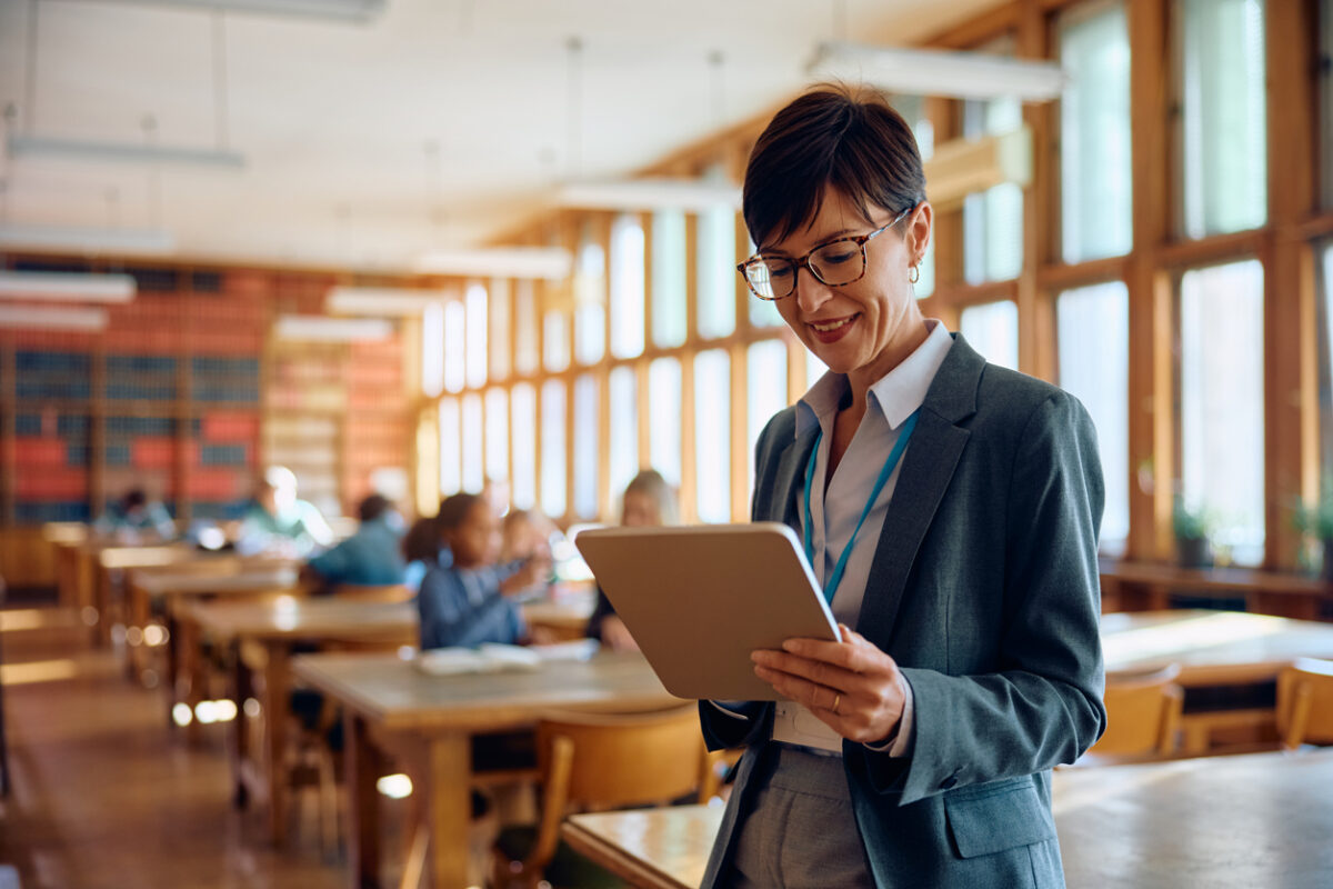 smiling education professional looking at a laptop 