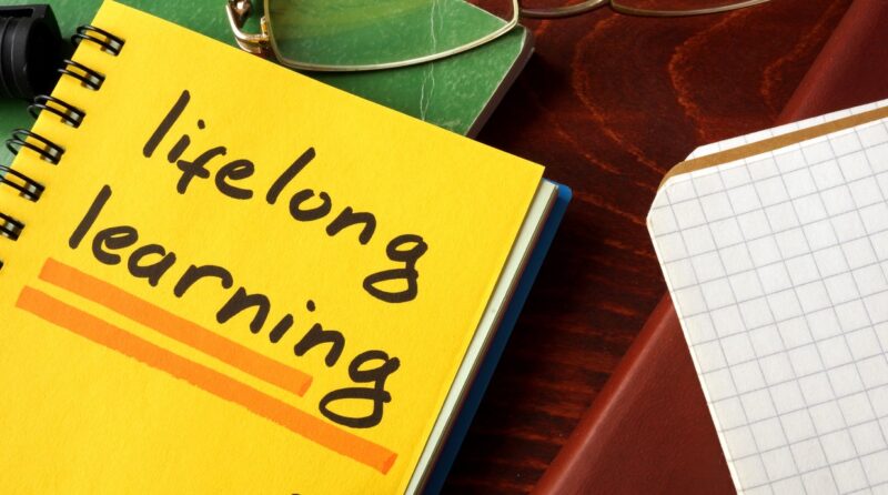 Notebook with lifelong learning  sign on a table.