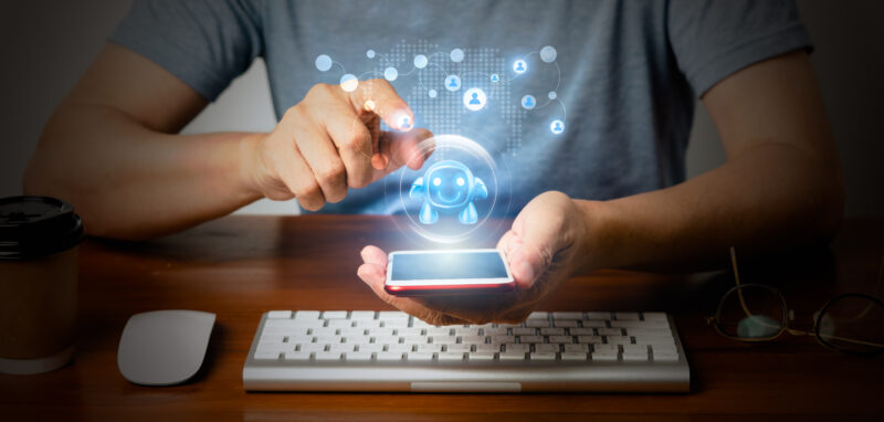 A person is working on a keyboard and smartphone, looking fuutristic