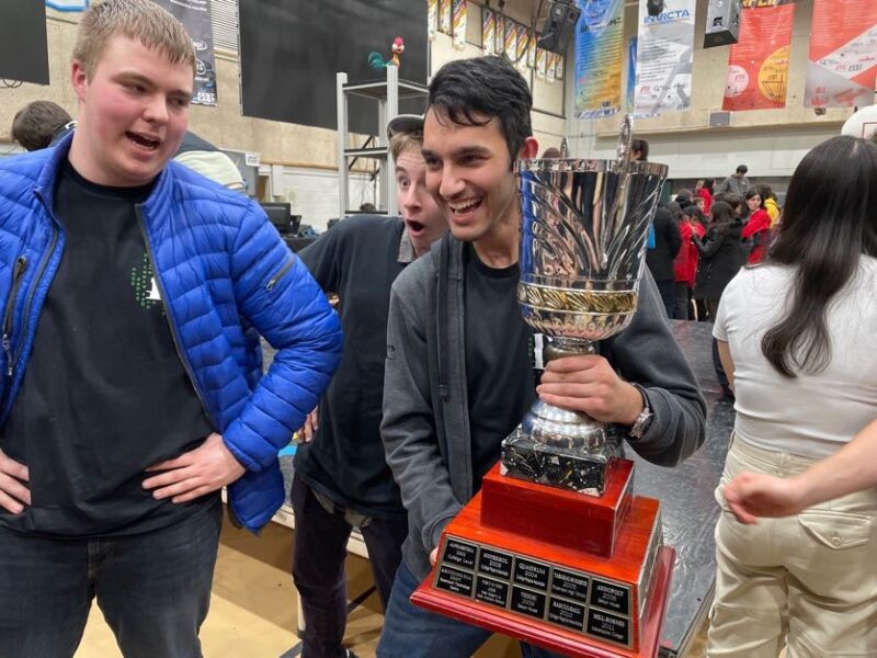 Membre de l'équipe de robotique de Dawson avec un trophée lors de la compétition de robotique du CRC.