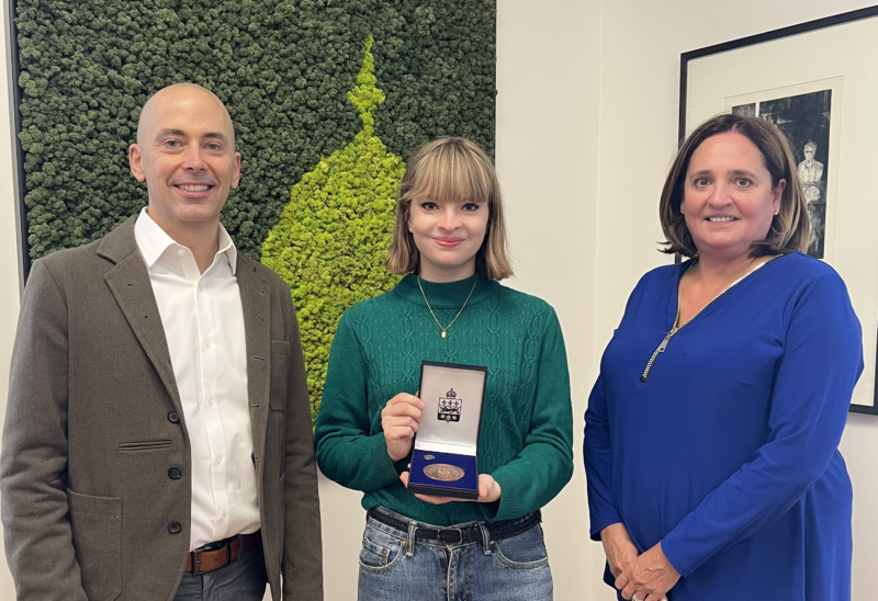 Arwen Low pose avec sa médaille de la jeunesse du lieutenant-gouverneur en compagnie de la directrice générale Diane Gauvin (à droite) et de Robert Cassidy (directeur des études).