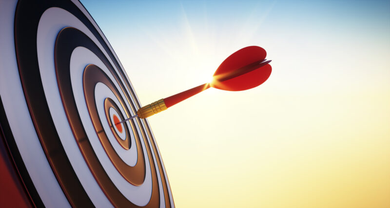 Close up shot of the dart arrow hitting on bullseye of dartboard