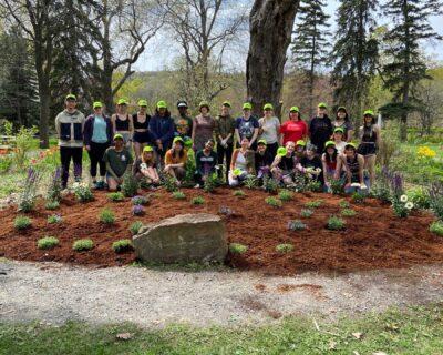 Students posing by recently planted garden