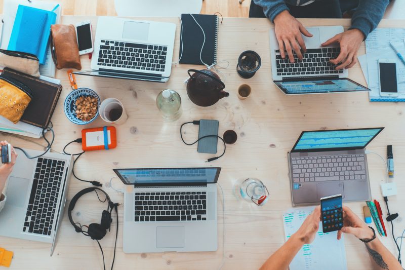 many computer on the table with other devices