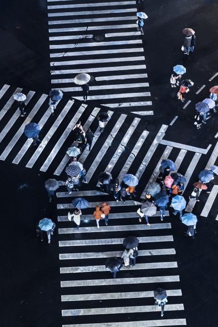 People with umbrellas crossing a street